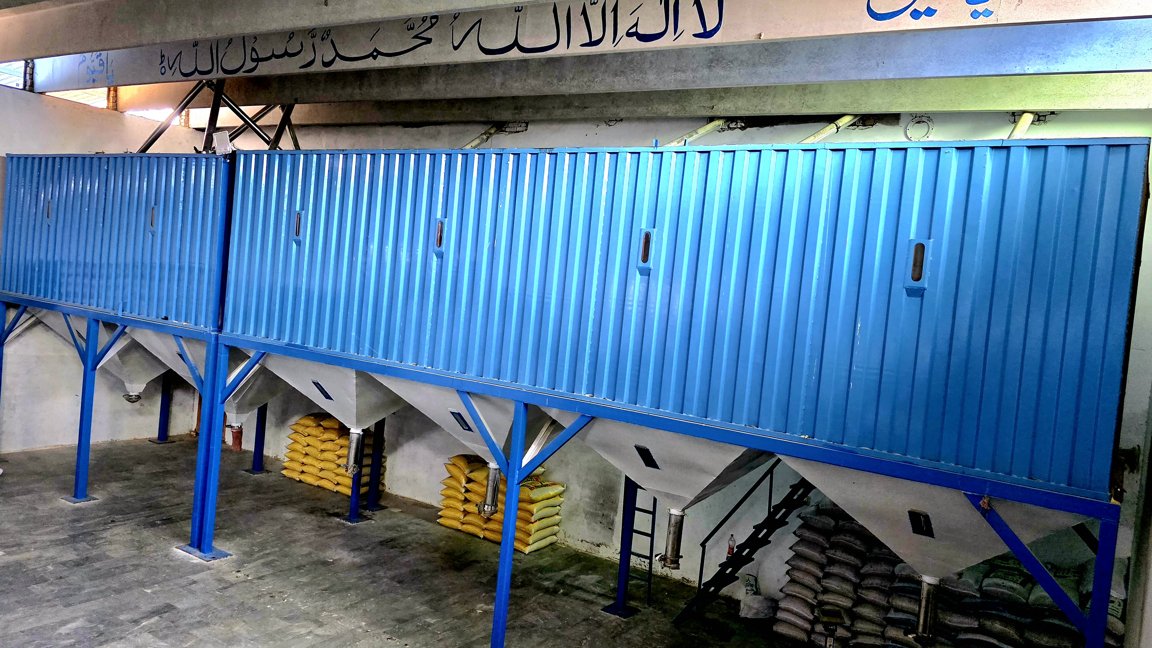 Storage bins supporting IRRI-6 Rice bulk preparation.